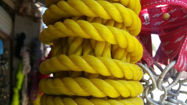 Closeup of bright color braided plastic ropes. Hanks or coil of bright colored plastic rope interwoven which are used for climbing and tightening materials.