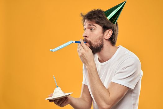 A bearded man with a cake and in a cap celebrating his birthday. High quality photo