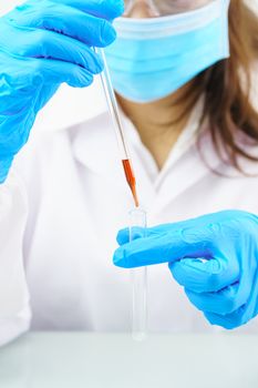 Technician scientist analyzing a blood sample in test tube in laboratory for testing it on COVID, COVID-19, coronavirus virus analysis