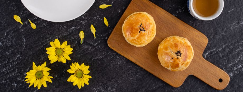 Moon cake yolk pastry, mooncake for Mid-Autumn Festival holiday, top view design concept on dark wooden table with copy space, flat lay, overhead shot