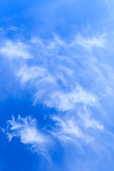 Vertical photo of Blue sky with delicate arabesques of light white cirrus clouds