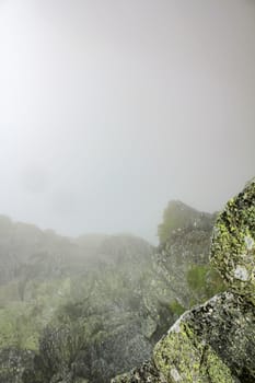 Fog, clouds, rocks and cliffs on Veslehødn Veslehorn mountain in Hemsedal, Norway.