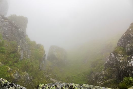 Fog, clouds, rocks and cliffs on Veslehødn Veslehorn mountain in Hemsedal, Norway.