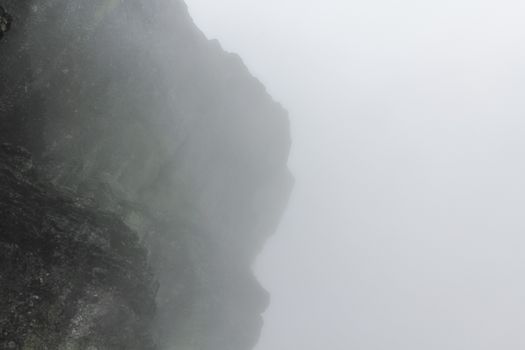 Fog, clouds, rocks and cliffs on Veslehødn Veslehorn mountain in Hemsedal, Norway.