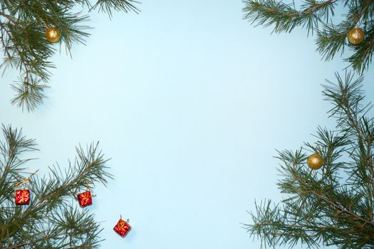 coniferous branches and Christmas tree decorations on a New Year's blue background, copy space