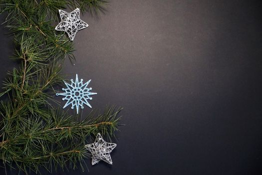 coniferous branches and Christmas tree decorations on a New Year's black background, copy space.