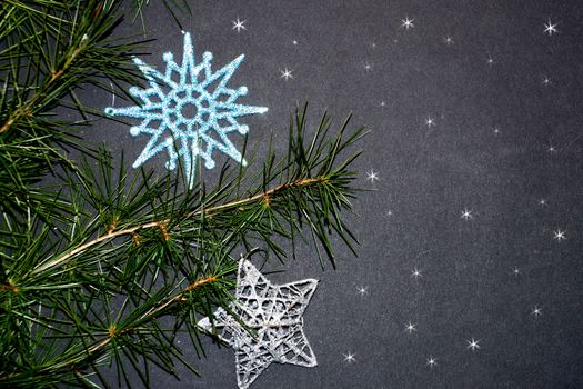 coniferous branches and Christmas tree decorations on a New Year's black background, copy space.