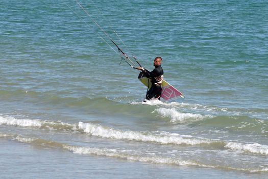 Varna, Bulgaria - September, 19, 2020: a man comes out of the sea with a kiteboard