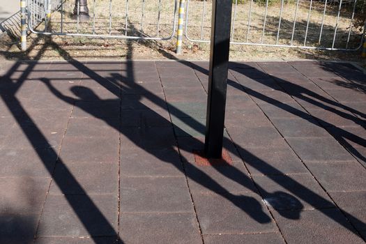 shadow of a man doing a horizontal bar in the park