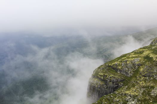 Fog, clouds, rocks and cliffs on Veslehødn Veslehorn mountain in Hemsedal, Norway.