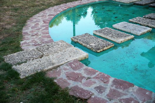 decorative pond with turquoise water in the park.