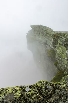 Fog, clouds, rocks and cliffs on Veslehødn Veslehorn mountain in Hemsedal, Norway.