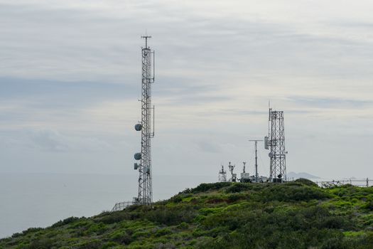 Telecommunication antennas on the top of mountain, SD, California, USA. Television, radio and communications antenna with numerous transmitters, Technology.