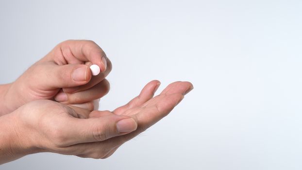 Close-up images of people taking or holding a medicine pill in hand which help and protect from pandemic virus and relief them from unhealthy and sickness. studio shot and clear background.