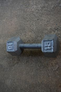 An Old Silver Fifteen Pound Weight on Concrete