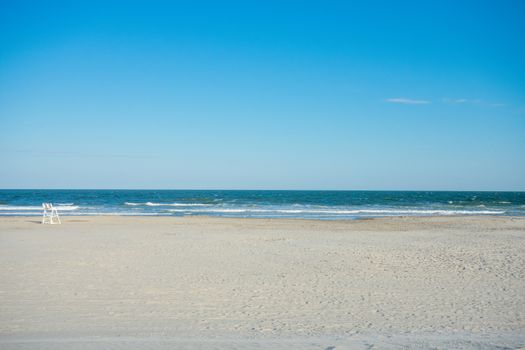 A Large Empty Beach and Ocean With a Lifeguard Chair on a Clear Blue sky in Wildwood New Jersey