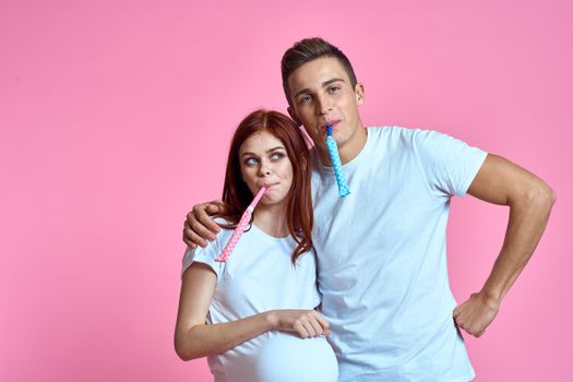 pregnant mom and happy father on pink background Young family waiting for baby. High quality photo