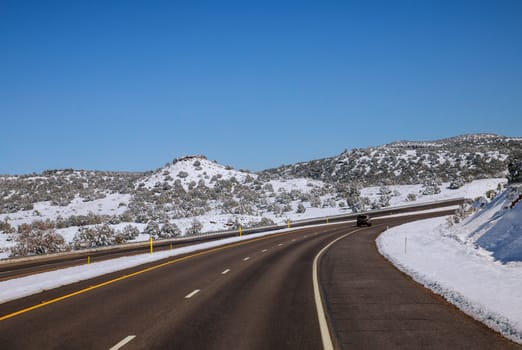 Highway road in mountains covered with snow USA