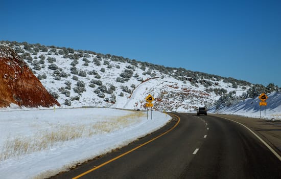 Winter road and trees with snow in Northern Wyoming landscape in the mountain