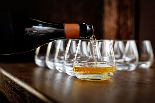 Waiter pouring wine into wineglass. Sommelier pours alcoholic drink