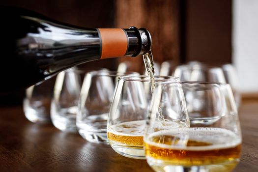 Pouring cider into glass from bottle