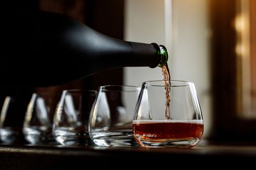 Pouring cider into glass from bottle