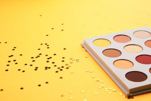 Eyeshadows on a yellow background professional cosmetics makeup brushes soft sponge fashion glasses. High quality photo