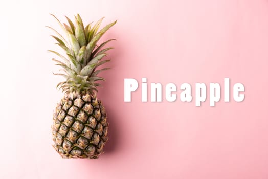 Close up above top view of ripe pineapple fruit on pink pastel background, Summer Tropical concept