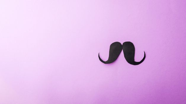 Black mustache paper, studio shot isolated on purple background, Prostate cancer awareness month, Fathers day, minimal November moustache concept