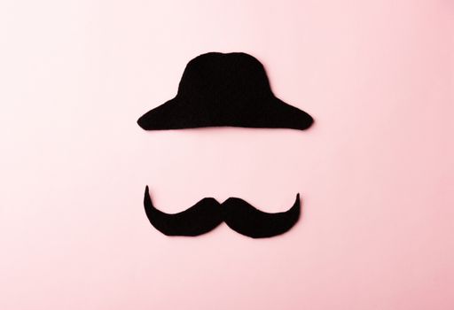 Black mustache and cap, studio shot isolated on pink background, Prostate cancer awareness month, Fathers day, minimal November moustache concept