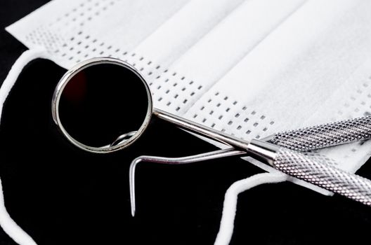 Set of metal Dentist's medical equipment tools on black backgound.