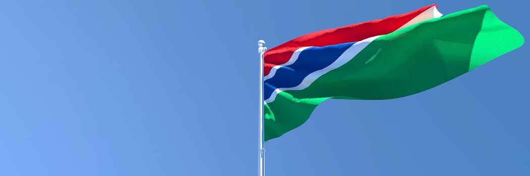3D rendering of the national flag of Gambia waving in the wind against a blue sky.
