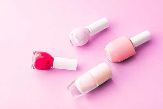 Nail polish bottles on pink background, beauty branding