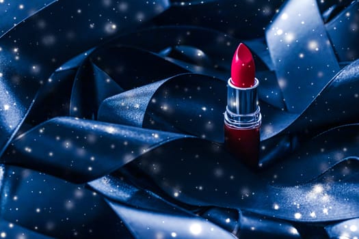 Red lipstick on blue silk and shiny glitter background, luxury make-up and beauty cosmetics