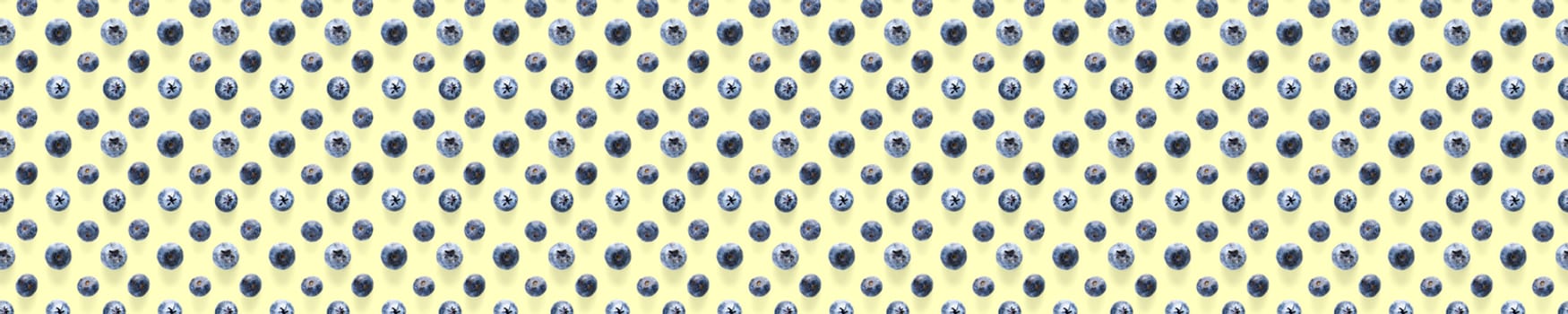Background of Freshly picked blueberries on yellow backdrop. Blackberry modern flatlay background.