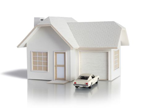 House miniature with white car isolated in white background for real estate and construction concepts. House miniature designed and created by contributor