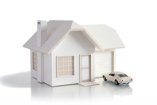 House miniature with white car isolated in white background for real estate and construction concepts. House miniature designed and created by contributor