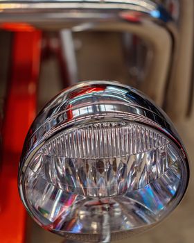 Close up of red classic car glass headlight