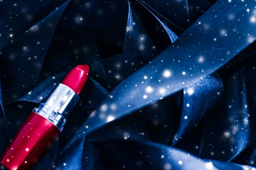 Red lipstick on blue silk and shiny glitter background, luxury make-up and beauty cosmetics