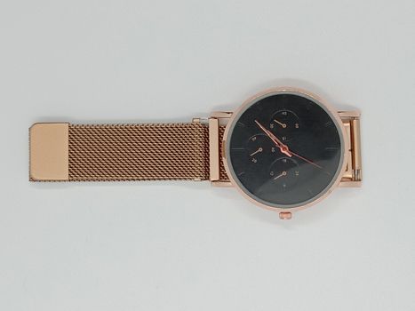 golden colored watch closeup on gray background