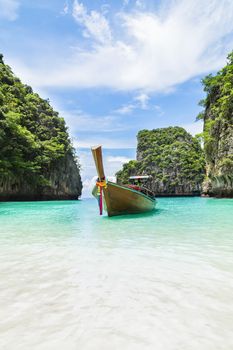 Thai traditional wooden longtail boat and beautiful beach in Phuket province, Thailand.