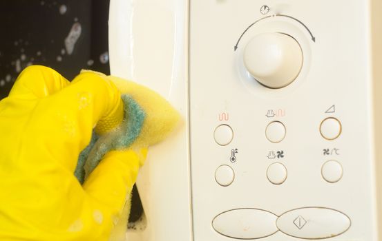 Microwave oven washing using a detergent solution with foam,closeup.Housework at kitchen.