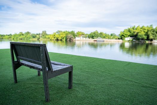 Wooden chair near river and green view.