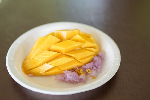Ripe mango and sticky rice(purple color from butterfly pea flower) with coconut milk Thai dessert.