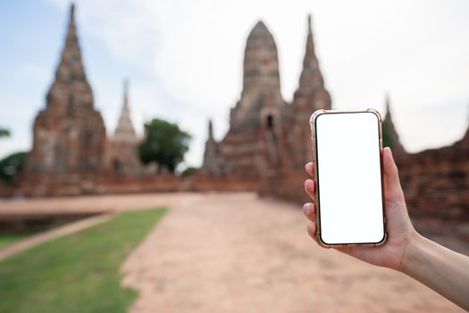 Mockup image of hand holding mobile phone with blank white screen with Pagoda.