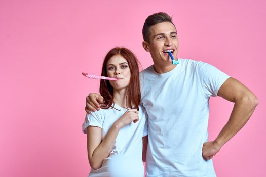 pregnant mom and happy father on pink background Young family waiting for baby. High quality photo