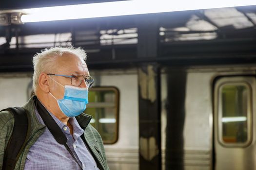Man in face disposable mask in the Covid-19 subway station coronavirus epidemic pandemic on train metro tube male health care.