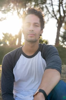 Portrait of young man in the park with beautiful sunset