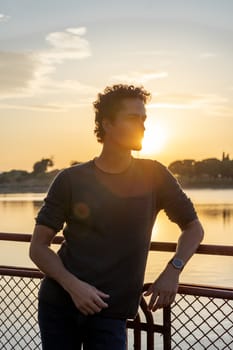 Portrait of young man in the lake with beautiful sunset