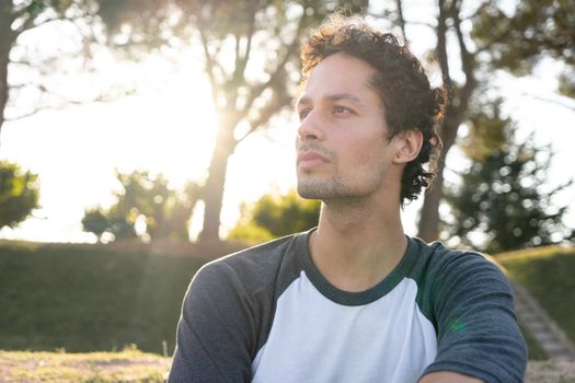 Portrait of young man in the park with beautiful sunset